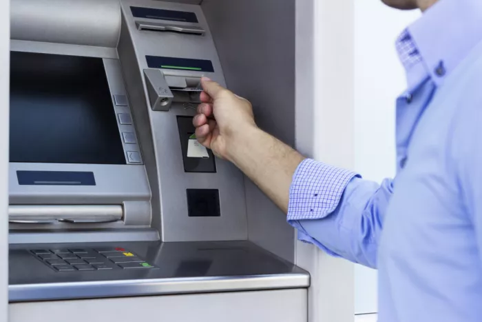 Férfi bankkártyát dug az ATM készülékbe