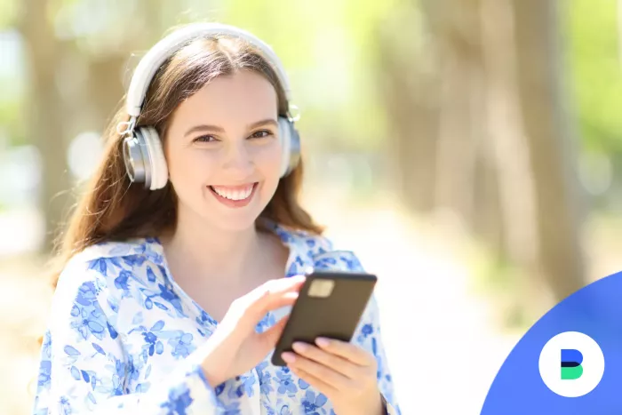 Lány nyomkodja a mobilbankját miközben zenét hallgat