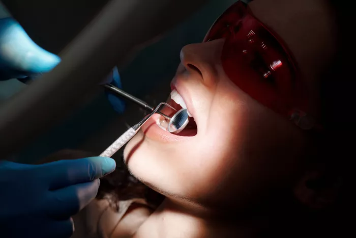 Fogászati vizsgálat közben matat a fogorvos a beteg szájában