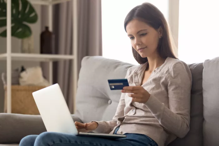 A lány hitelkártyával vásárol a laptopján