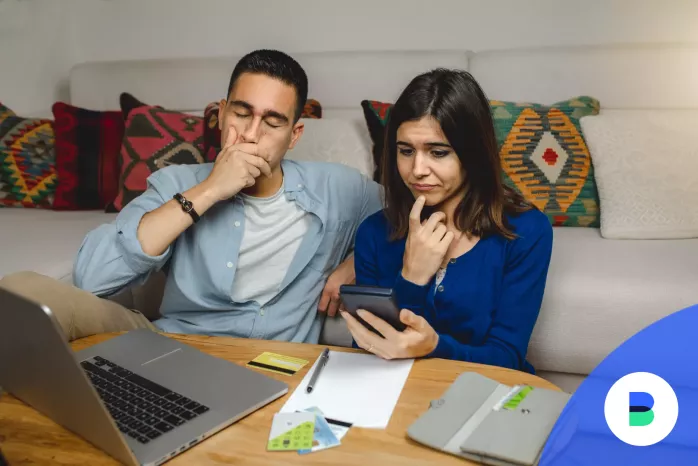 Házaspár a kamatos kamatot számolja ki számológéppel és laptoppal