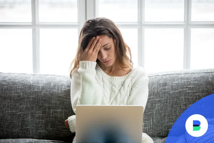 Szomorú nő rossz híreket olvas a laptopján banki díjemelésekről