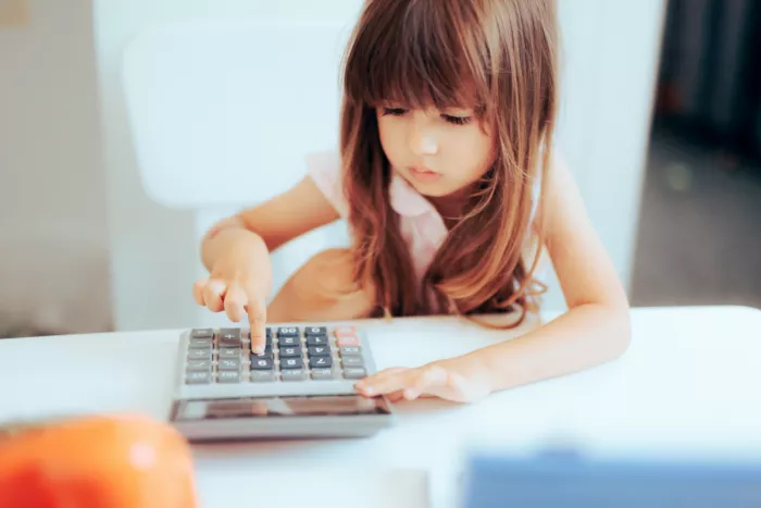 Kislány számológéppel kiszámolja a megtakarítási számla kamatát