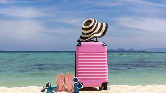 Bőrönd kalappal a tengerparton