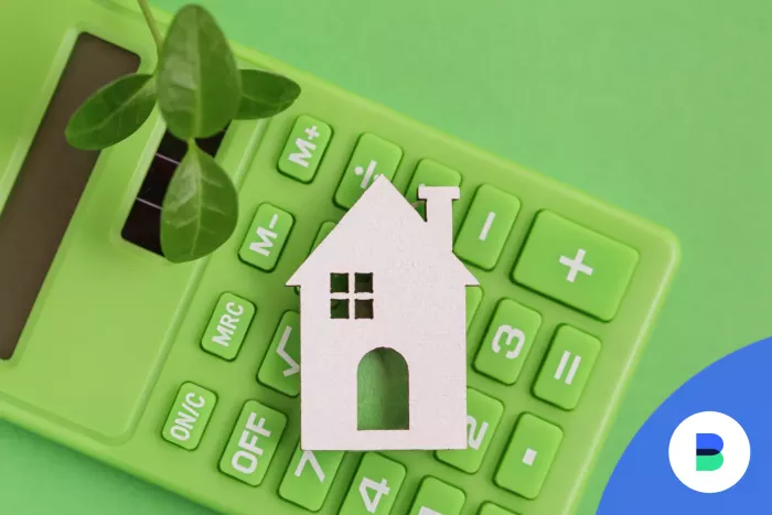 Zöld számológép és rajta egy ház
