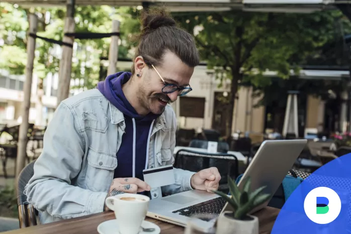 Vállalkozó egy laptoppal egy kávézóban intézi a céges vásárlásait