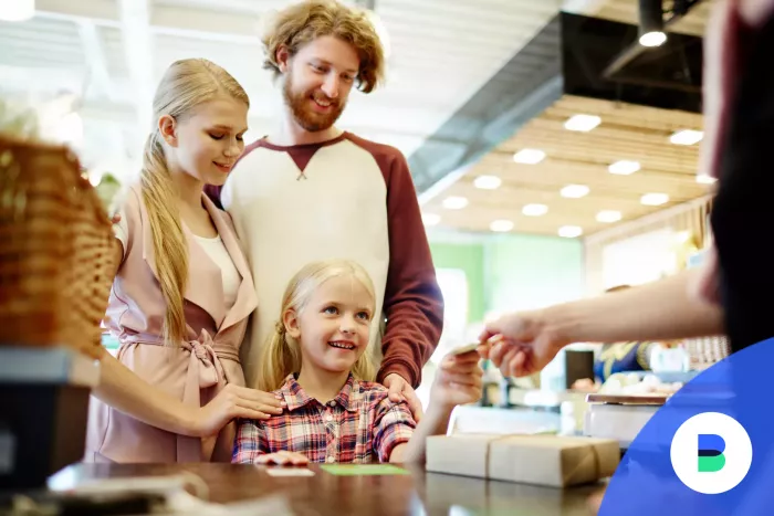 Kislány átadja a bankkártyát a bolti fizetéshez a pénztárosnak