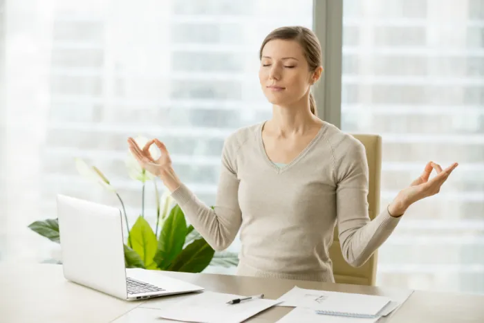 irodai asztalnál meditáló lány