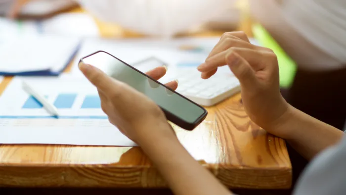 Nő csak mobiltelefont használva intézi a pénzügyeit