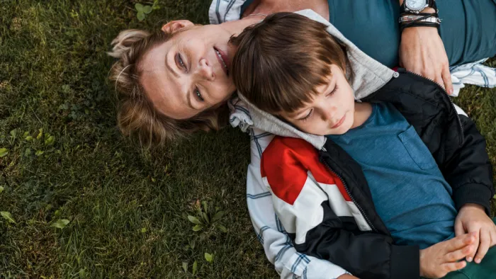 anyag a kisfiával fekszik a fűben