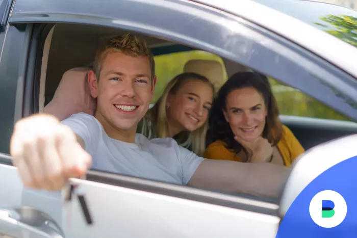 Három fiatal mosolyog egy autóból