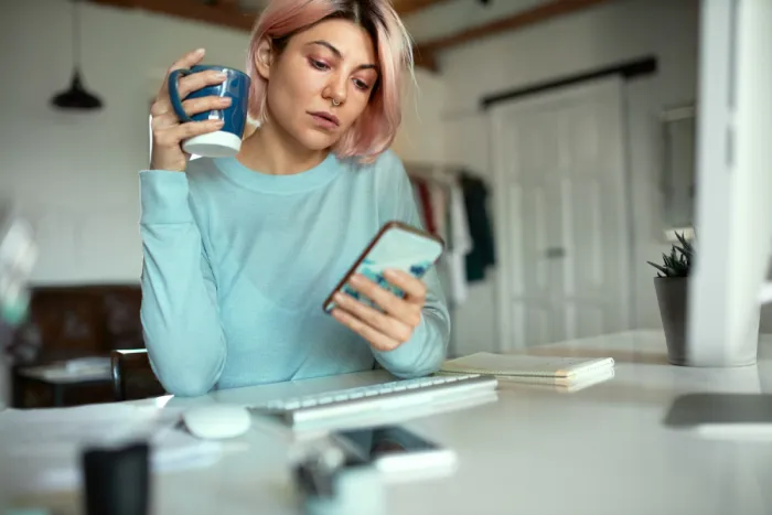 gyorskölcsönt mobiltelefonról igénylő fiatal nő