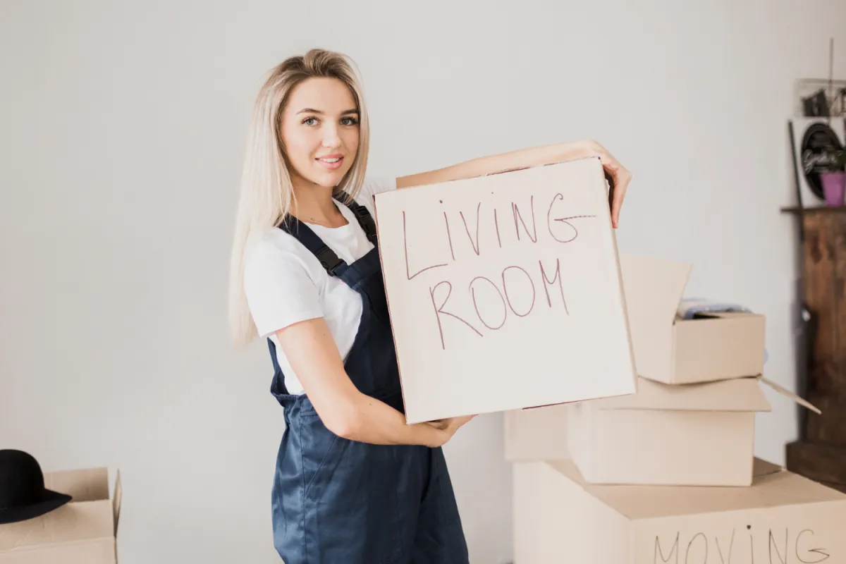 fiatal szőke lány költözés közben dobozokkal