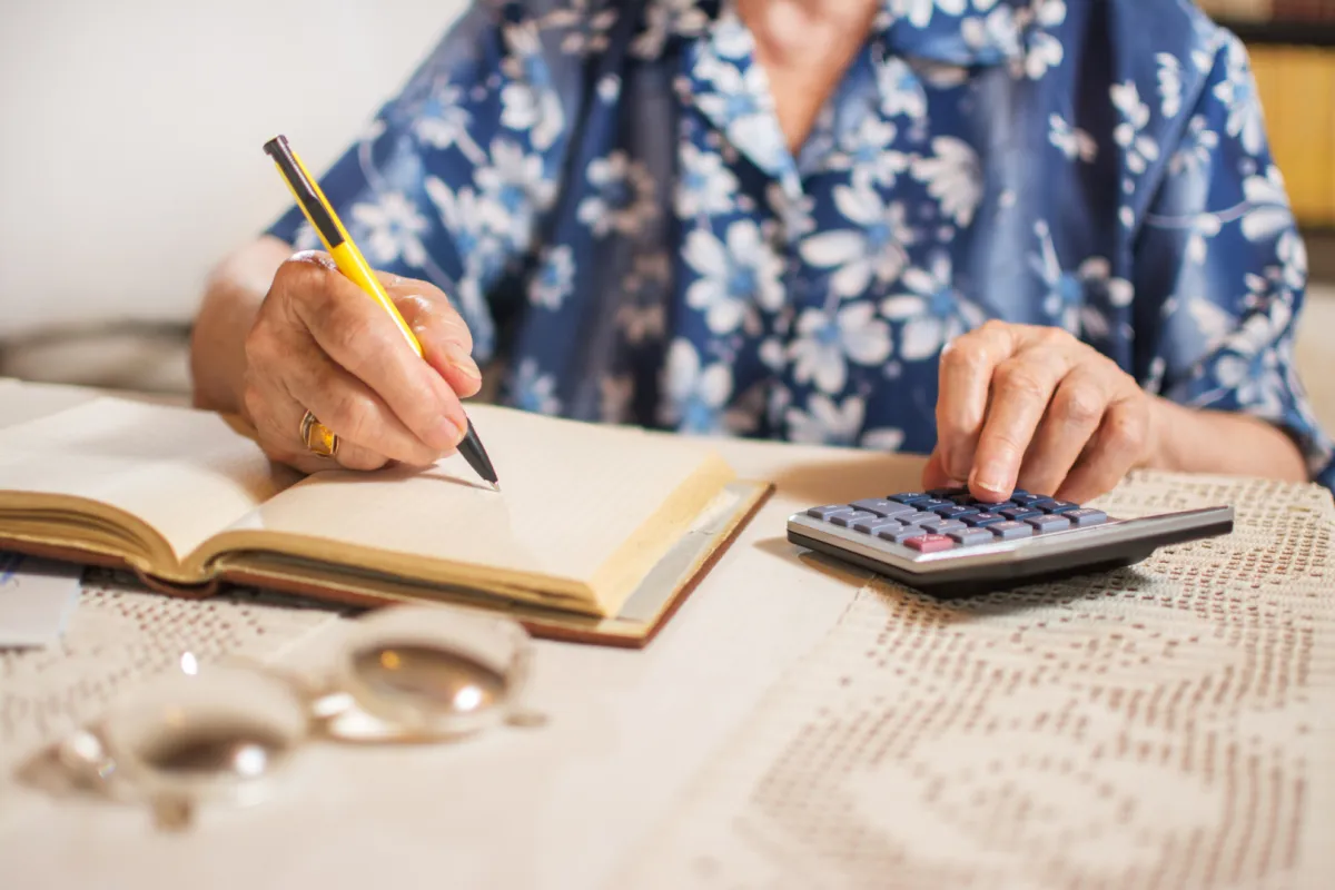 Idősebb nő utánaszámol, hogy a bank jól számította-e fel a díjat
