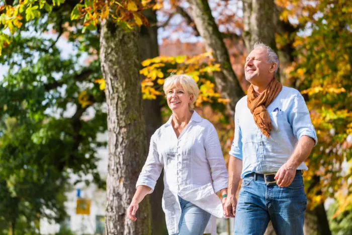 Nyugdíjas házaspár mosolyogva sétál
