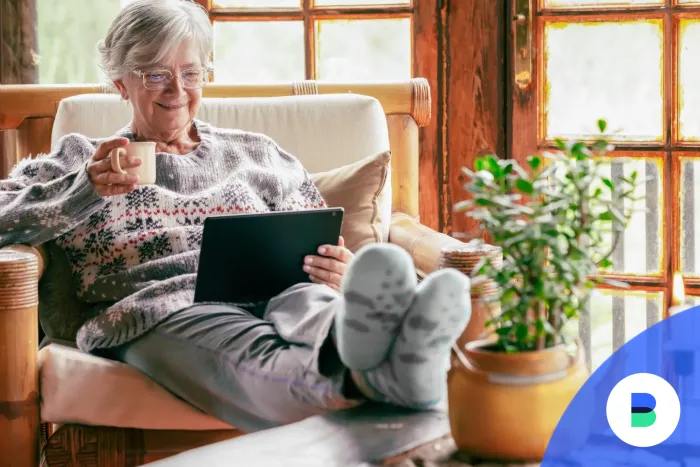 Nyugodt nyugdíjas tableten olvas és kávét iszik