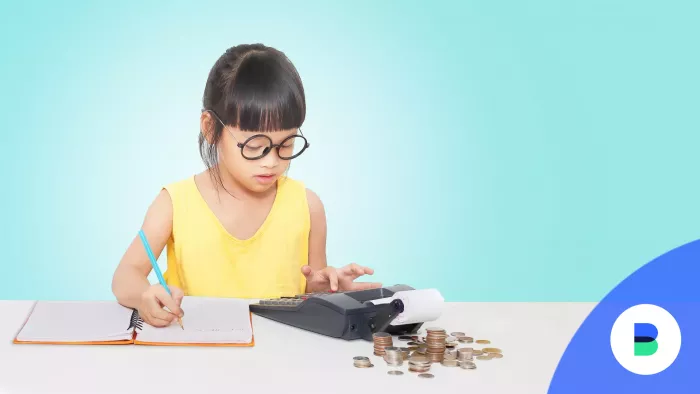 Kislány számolja pénztárgéppel az otthoni megtakarítását
