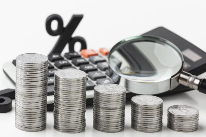 Mi a maginfláció? – Mi a hatása a gazdaságra? Pénz, számológép, nagyító és százalék jel