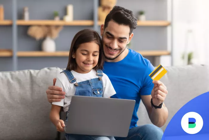 Férfi tanítja a kislányát a bankkártya használatra