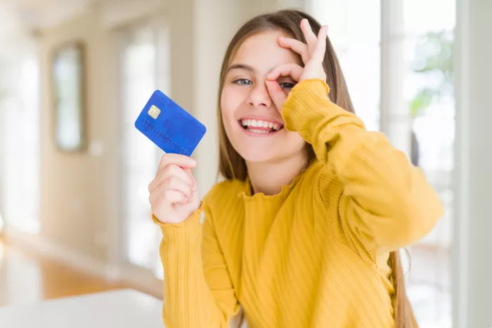 Fiatal lány bankkártyával a kezében