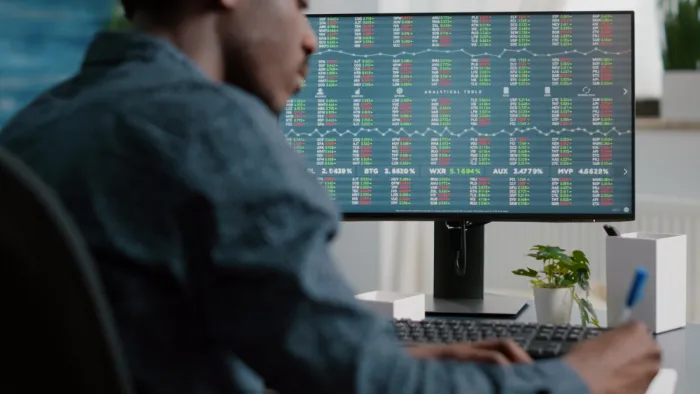 spreadet figyel, elemez egy férfi a monitor előtt
