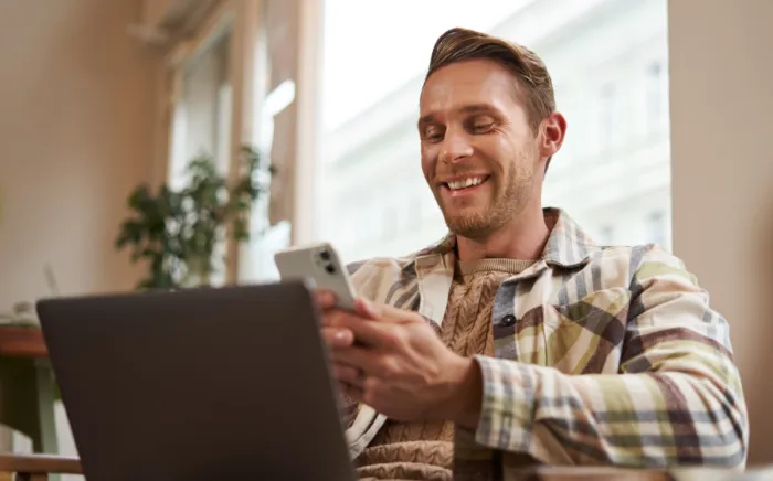 Vidám férfi mobiltelefonnal