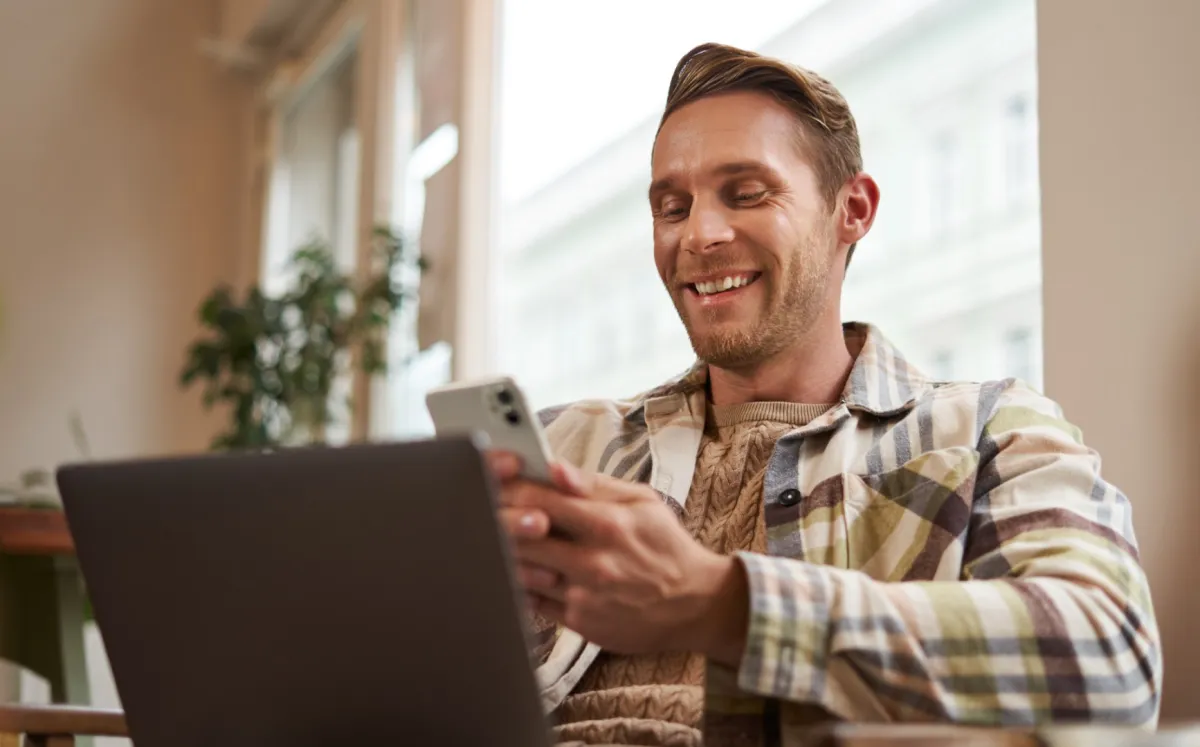 Vidám férfi mobiltelefonnal