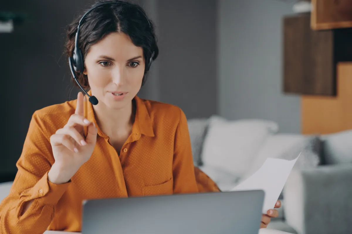 videóhívásban laptop képernyő előtt fiatal nő instruál